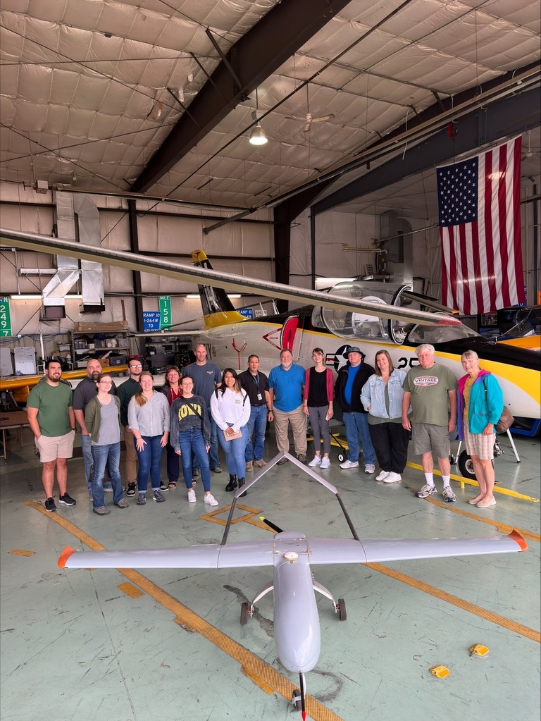 A group of people in front of a jet