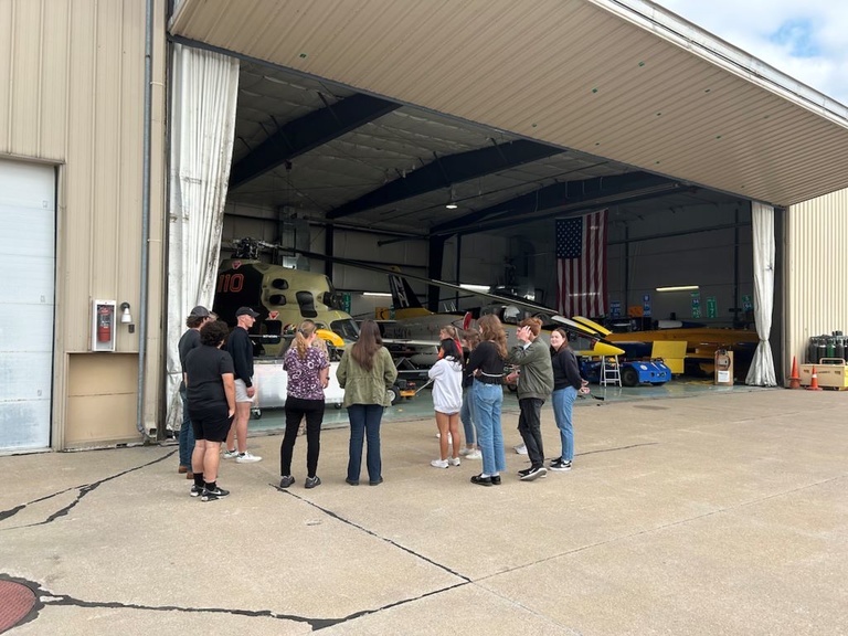 A tour group stands outside the OPL hangar