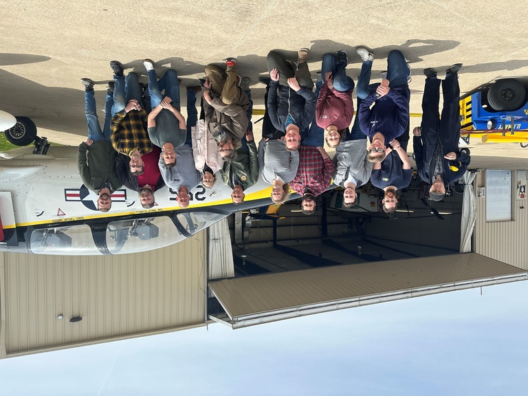 A group of people in front of a jet