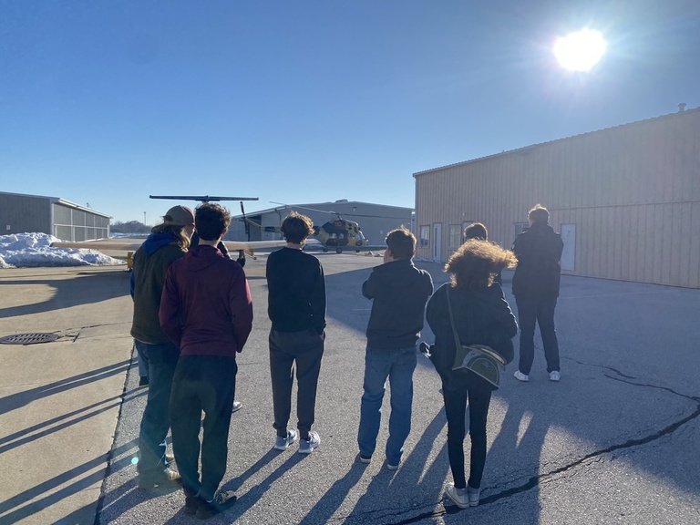 A group standing outside a hangar