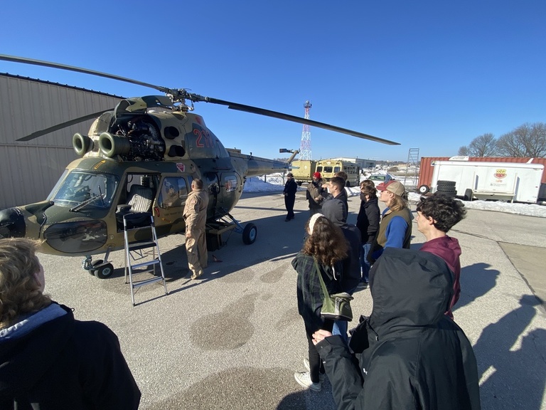 A group of students looking at a helicopter