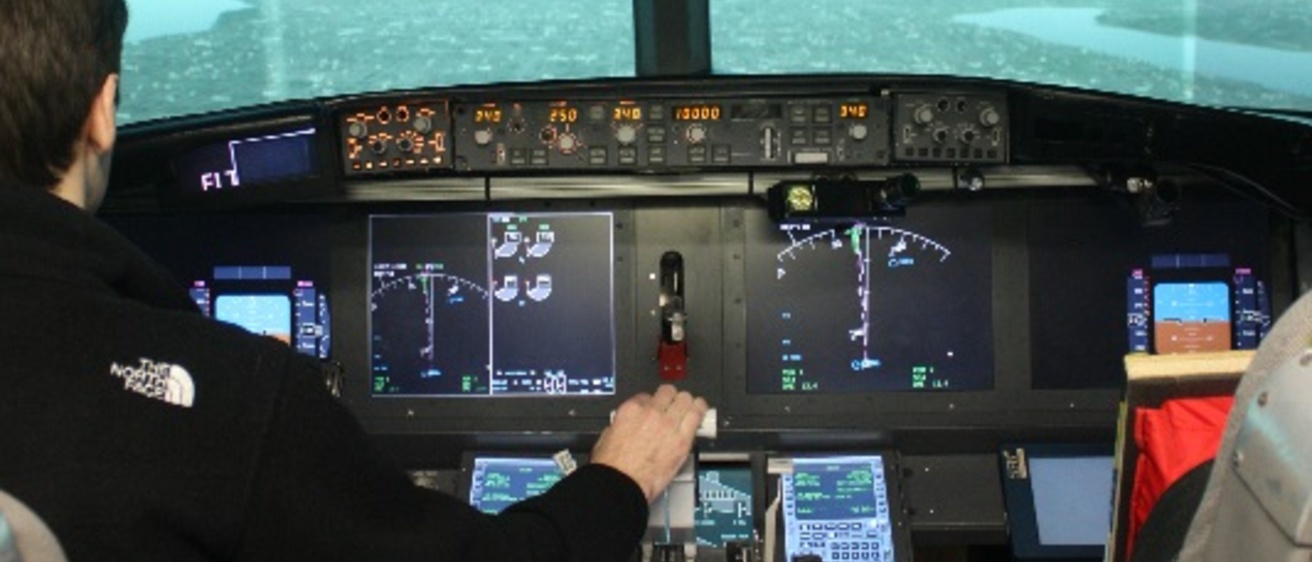 A pilot using the controls in an aircraft simulator