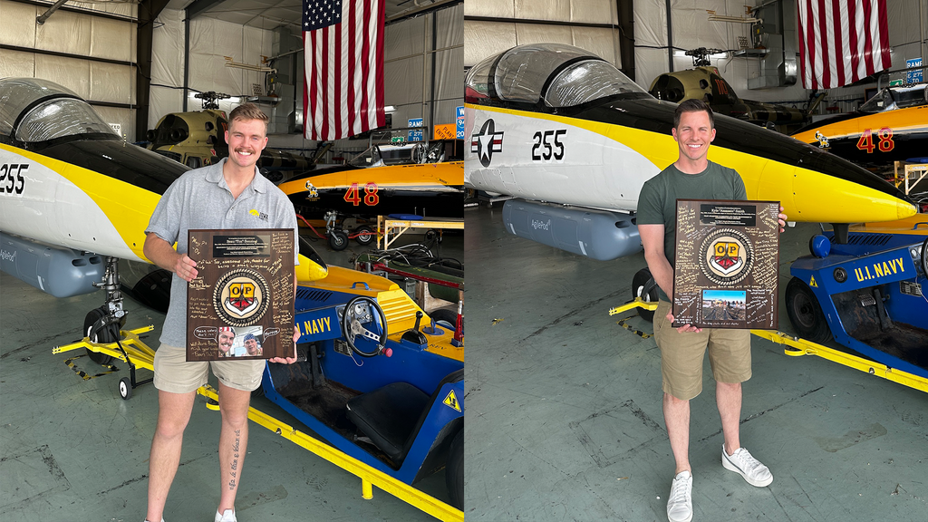 Beau Benzing, left, Kyle Smith, right, pose in front of a white jet. 